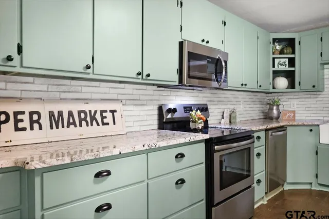 a kitchen with stainless steel appliances granite countertop a sink and a stove