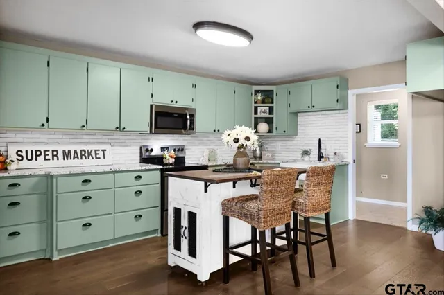 a kitchen with granite countertop a stove a sink and a refrigerator