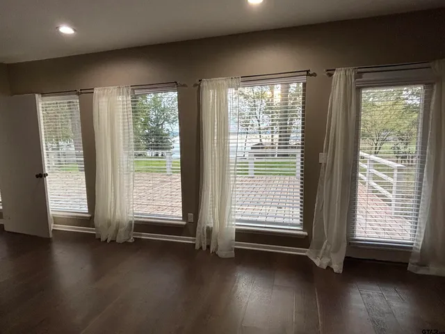 a view of room with wooden floor and windows