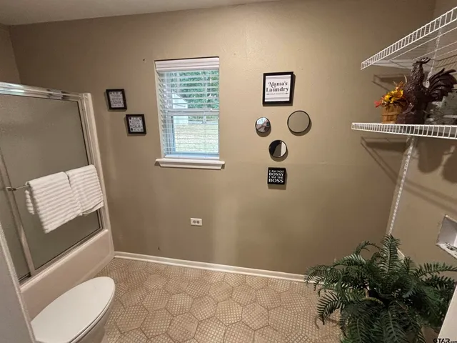 a bathroom with a toilet and a shower