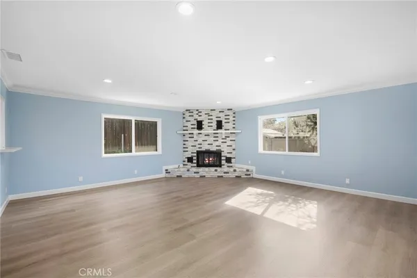 an empty room with a fireplace and windows