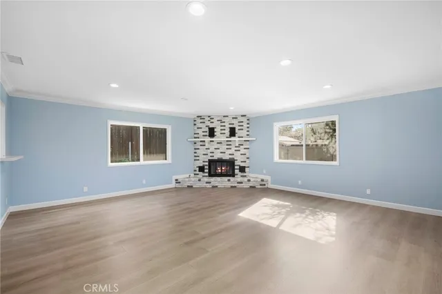 an empty room with a fireplace and windows