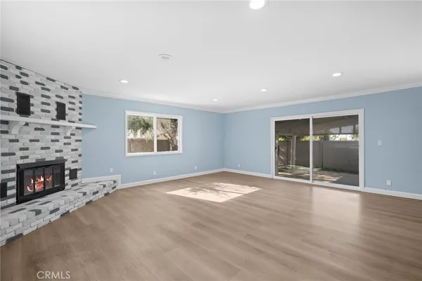 a view of an empty room with a fireplace and a window