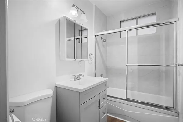 a bathroom with a shower sink vanity and toilet