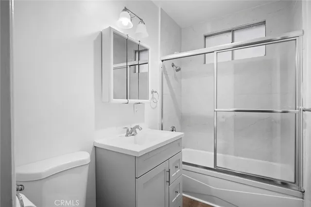 a bathroom with a shower sink vanity and toilet