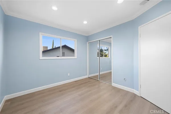 an empty room with closet and windows