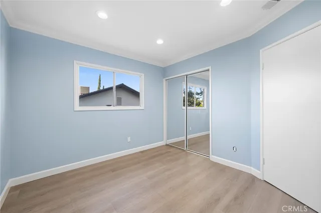 an empty room with closet and windows