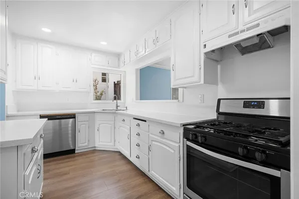 a kitchen with granite countertop white cabinets and appliances