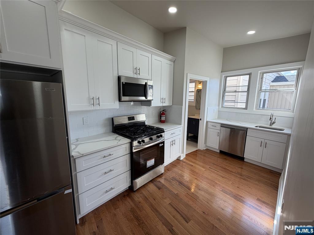 24-30 Pleasant, Unit 2 EAST Maywood, NJ 07607 - Photo 3 of 13 a kitchen with stainless steel appliances a refrigerator stove and sink