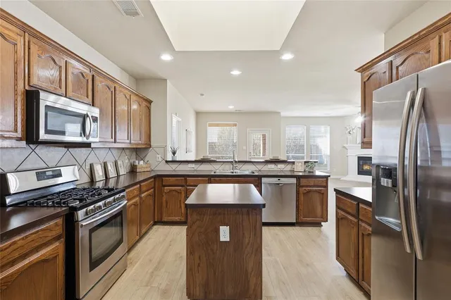 a kitchen with granite countertop stainless steel appliances and wooden cabinets