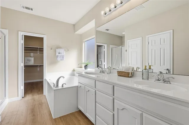 a bathroom with double vanity sinks a mirror and a shower