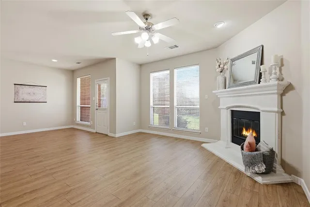 a view of a livingroom with a fireplace a chandelier and wooden floor