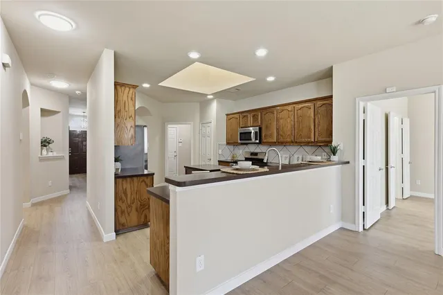 a kitchen with stainless steel appliances a refrigerator and a stove top oven