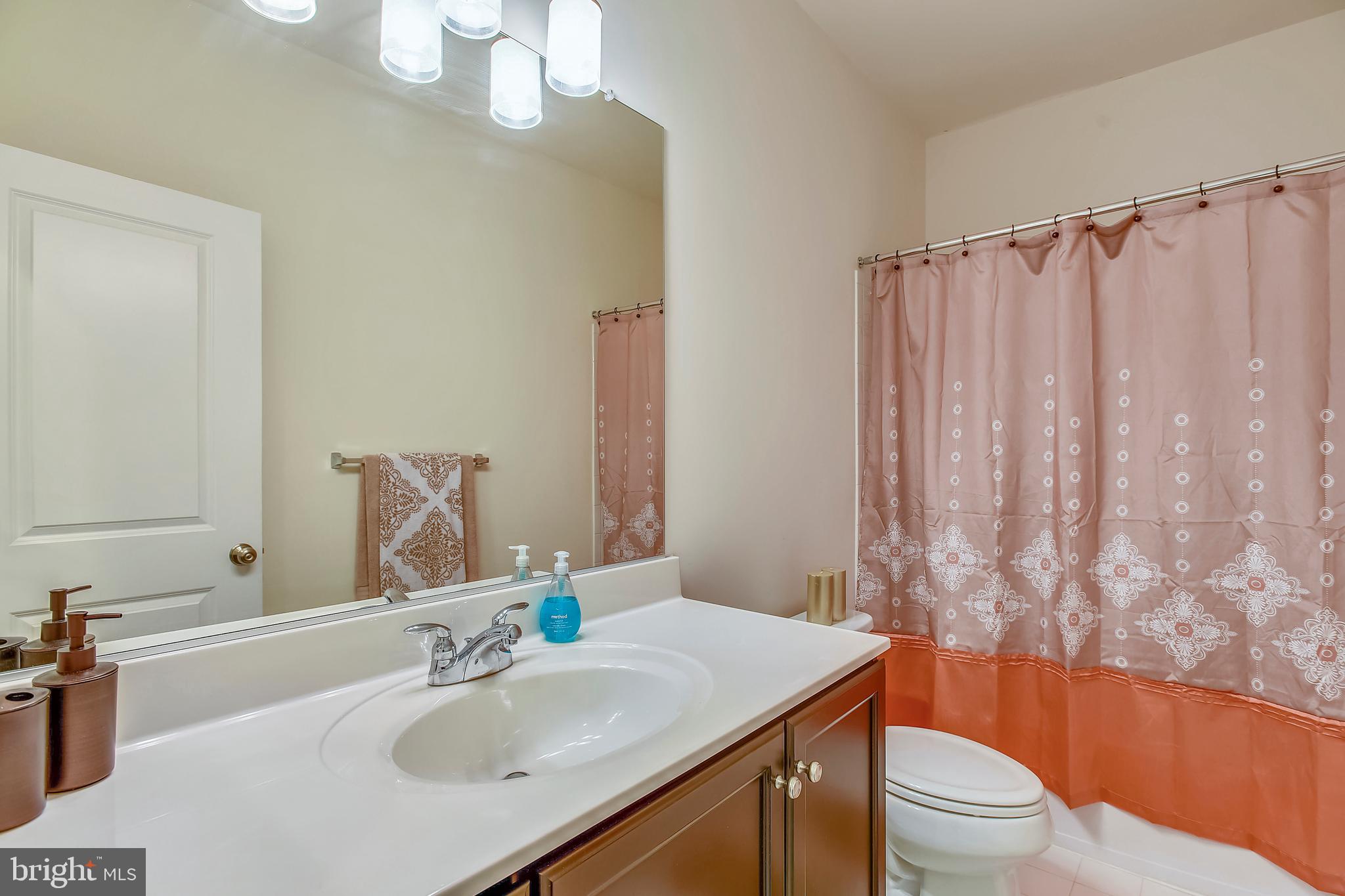 42243 Riggins Ridge Terrace Brambleton, VA 20148 - Photo 22 of 39 a bathroom with a sink a toilet and shower curtain