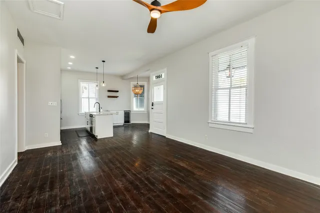 a view of empty room with wooden floor and windows