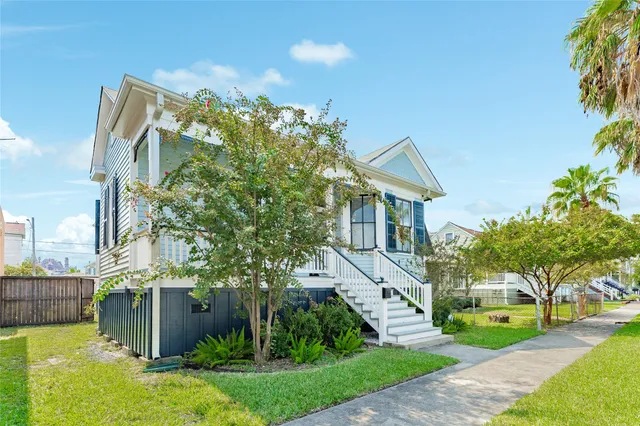 a front view of a house with a yard and a garden