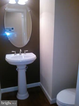 a bathroom with a sink toilet and a mirror