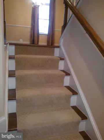 a view of staircase with white walls and a window