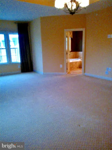 a view of an empty room with a fireplace and a window