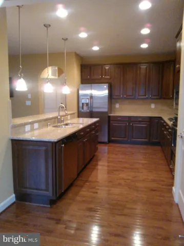a kitchen with kitchen island a sink stainless steel appliances and cabinets