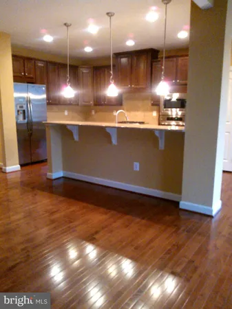 a view of kitchen with stainless steel appliances granite countertop cabinets and wooden floor