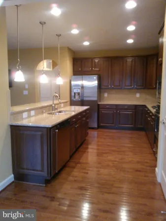 a kitchen with kitchen island a sink stainless steel appliances and cabinets