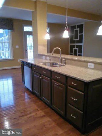 a kitchen with stainless steel appliances granite countertop a sink a stove and a wooden floors