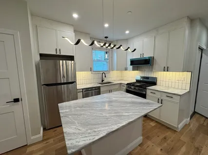 a kitchen with stainless steel appliances granite countertop a refrigerator and a stove top oven