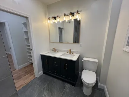 a bathroom with a sink vanity and toilet