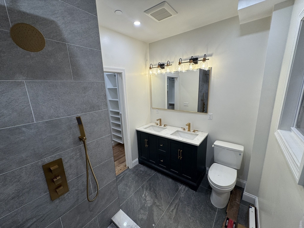 16 Harriet Street, Unit 1 Boston, MA 02135 - Photo 16 of 29 a bathroom with a toilet sink and mirror