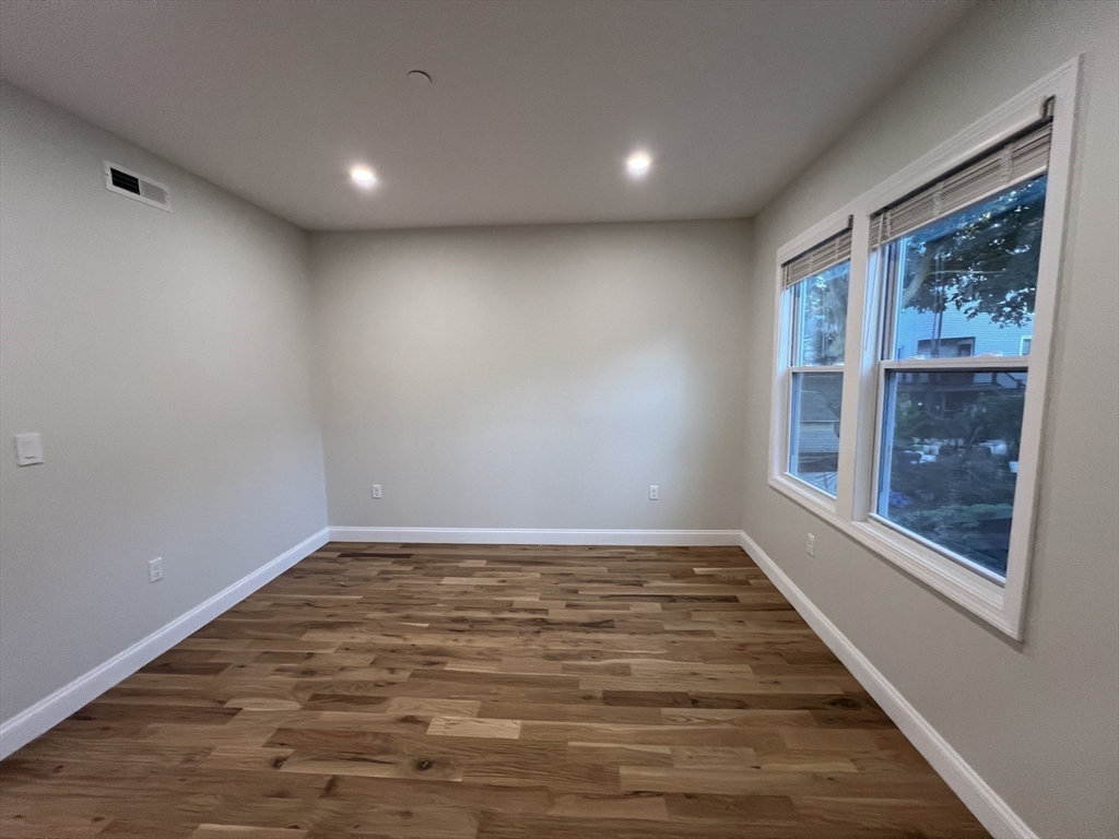 16 Harriet Street, Unit 1 Boston, MA 02135 - Photo 19 of 29 a view of an empty room with wooden floor and a window
