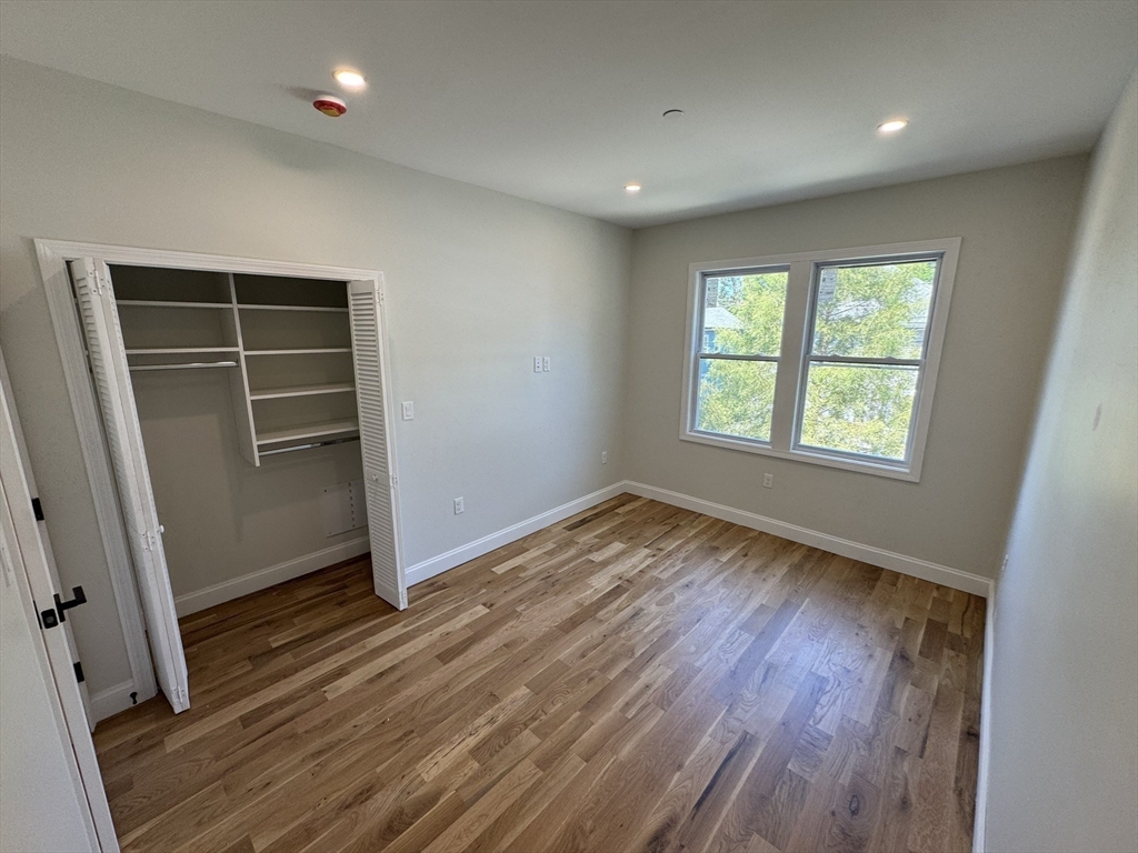 16 Harriet Street, Unit 1 Boston, MA 02135 - Photo 22 of 29 an empty room with wooden floor and windows