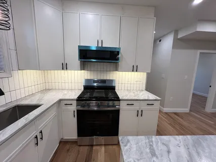 a kitchen with a stove and white cabinets