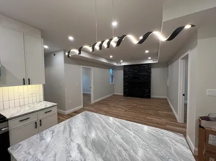 a view of an empty room and kitchen view