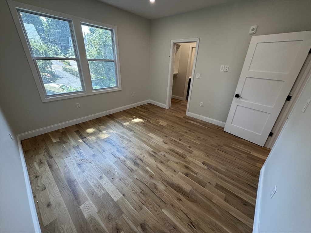 16 Harriet Street, Unit 1 Boston, MA 02135 - Photo 10 of 29 a view of empty room with wooden floor and fan