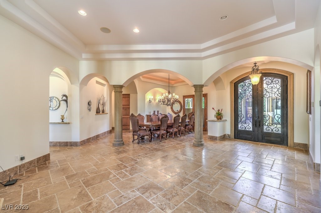 2780 El Camino Road Las Vegas, NV 89146 - Photo 26 of 91 Foyer with a chandelier, arched walkways, french doors, a raised ceiling, and stone tile flooring