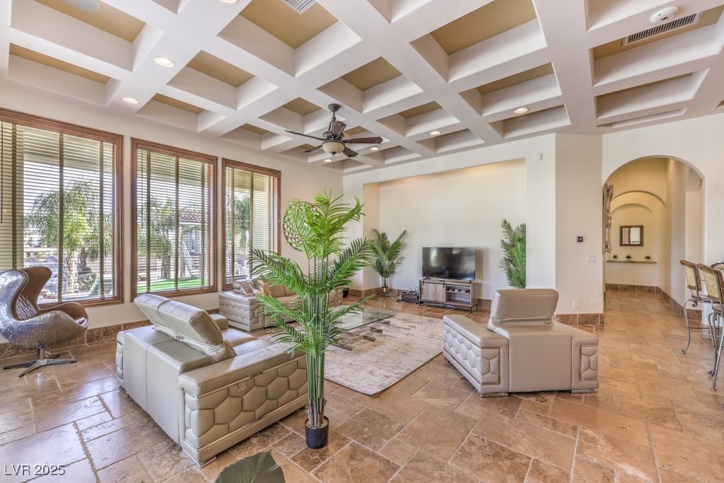 2780 El Camino Road Las Vegas, NV 89146 - Photo 30 of 91 Living room featuring stone tile flooring, coffered ceiling, arched walkways, ceiling fan, and beamed ceiling