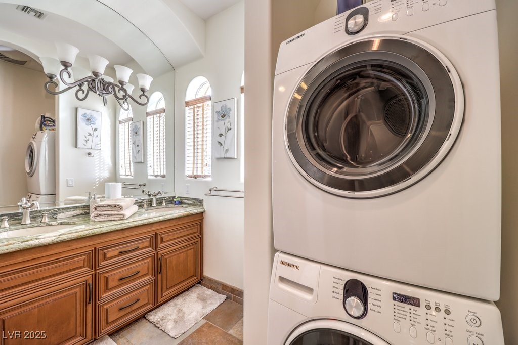 2780 El Camino Road Las Vegas, NV 89146 - Photo 69 of 91 Laundry room with a chandelier and stacked washing machine and dryer