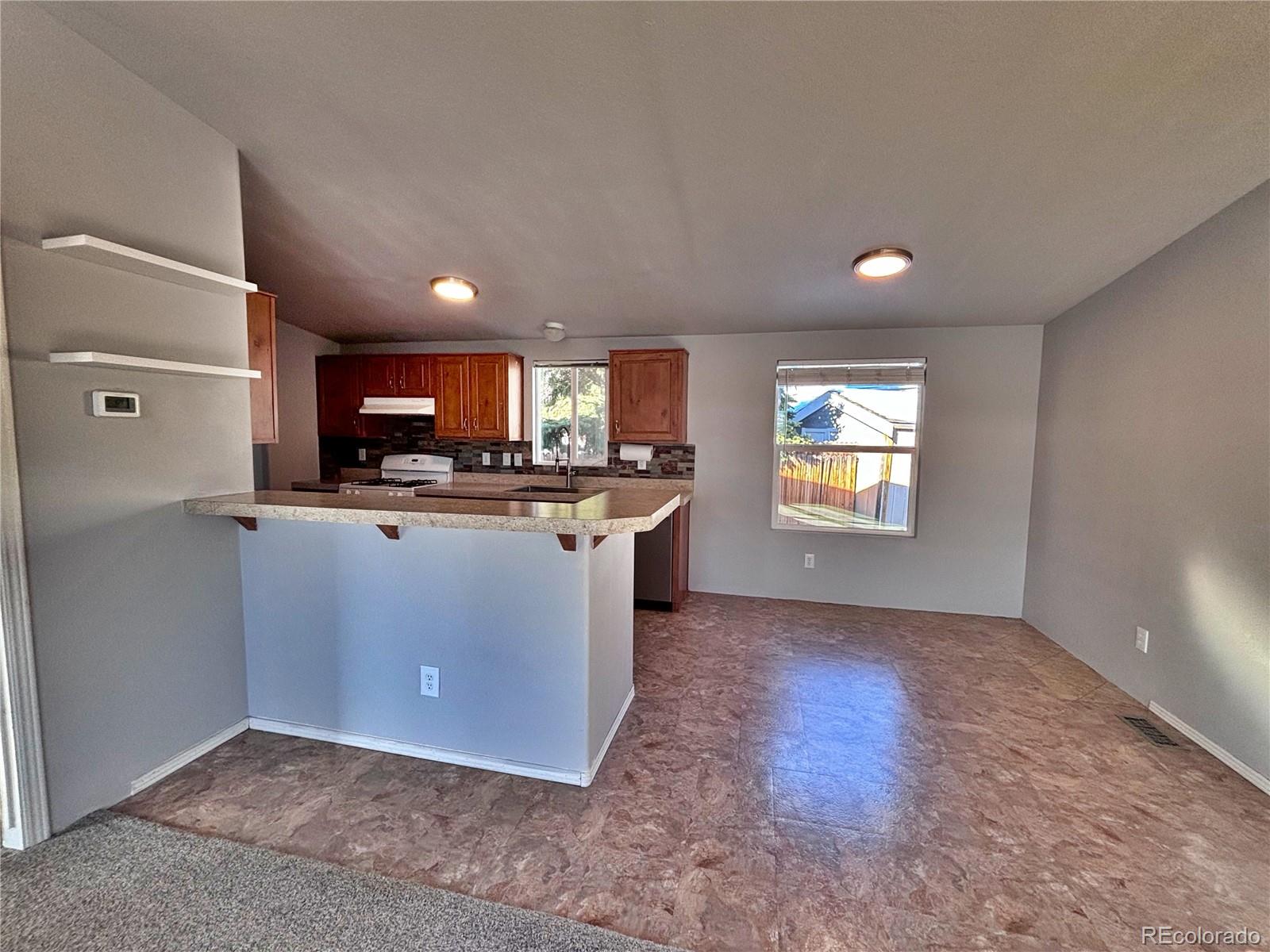 155 A Street Golden, CO 80401 - Photo 15 of 49 a kitchen with kitchen island granite countertop a sink cabinets and stainless steel appliances