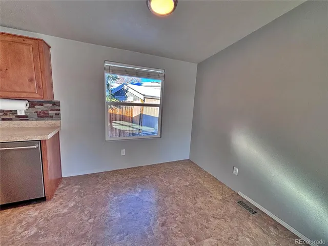 a kitchen with stainless steel appliances granite countertop a refrigerator a sink dishwasher a stove a washer and dryer with wooden cabinets