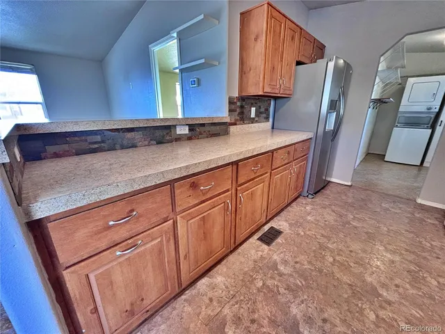 a kitchen with stainless steel appliances granite countertop a stove a sink dishwasher a refrigerator and a stove