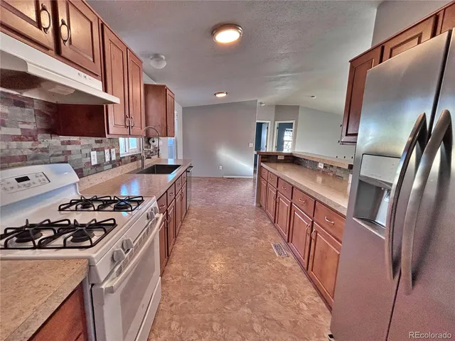 a kitchen with metallic refrigerator freezer and a dishwasher with wooden floor