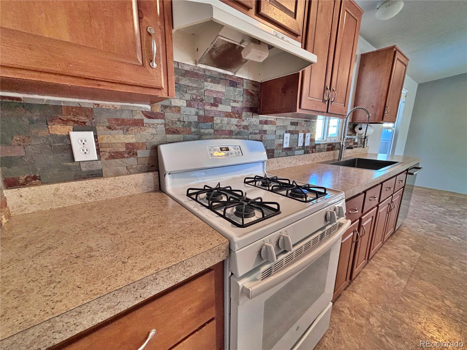 155 A Street Golden, CO 80401 - Photo 23 of 49 a kitchen with granite countertop a stove and a sink