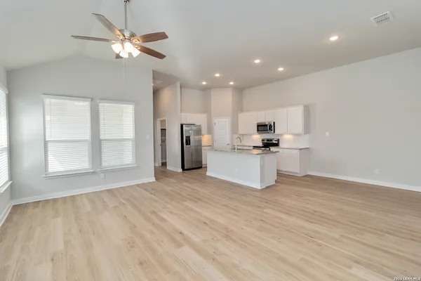 a view of kitchen with granite countertop cabinets and refrigerator