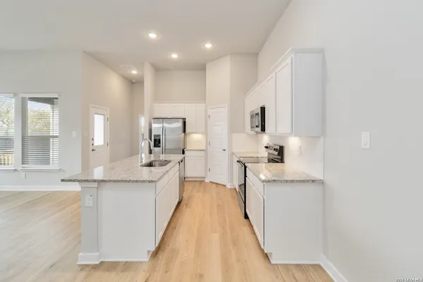 a large kitchen with kitchen island a sink stainless steel appliances and cabinets