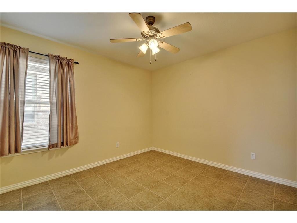 2109 Granite Springs Road Leander, TX 78641 - Photo 15 of 30 A quiet, well-lit bedroom features ceramic tile flooring and a functional ceiling fan.
