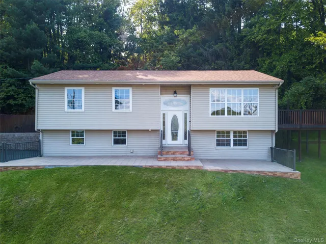 a view of a house with a yard and sitting area