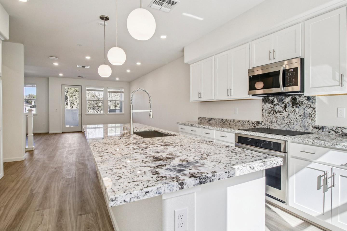 3769 Castro Valley Boulevard Castro Valley, CA 94546 - Photo 12 of 33 a kitchen with stainless steel appliances granite countertop a stove top oven a sink dishwasher and white cabinets with wooden floor