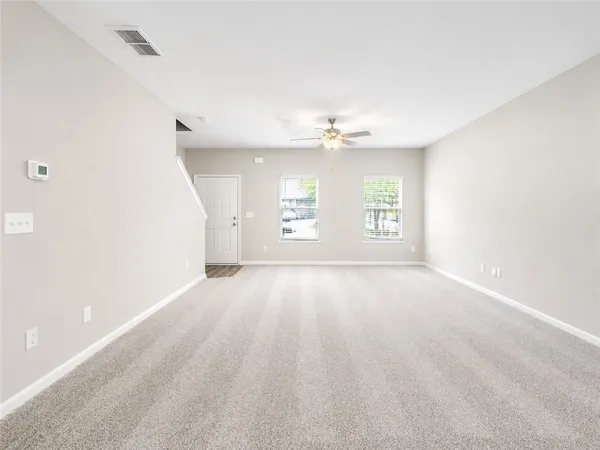 a view of empty room with wooden floor and window