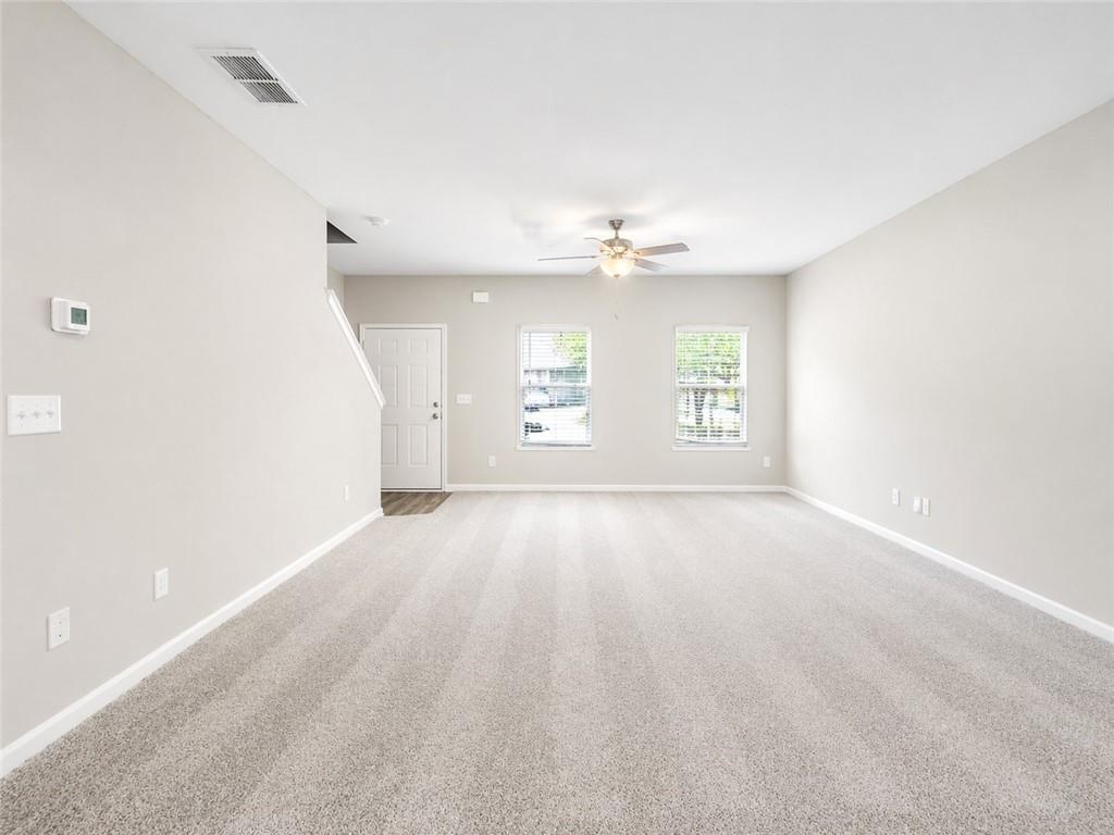 524 Rippling Court Temple, GA 30179 - Photo 2 of 19 an empty room with windows and chandelier fan